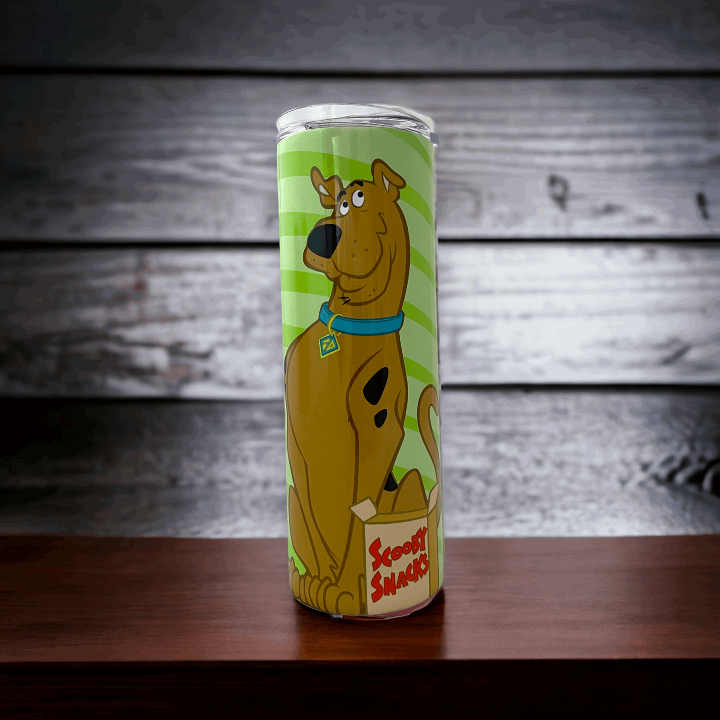 20oz tumbler with scooby doo design featuring Scooby holding Scooby Snacks on a green background