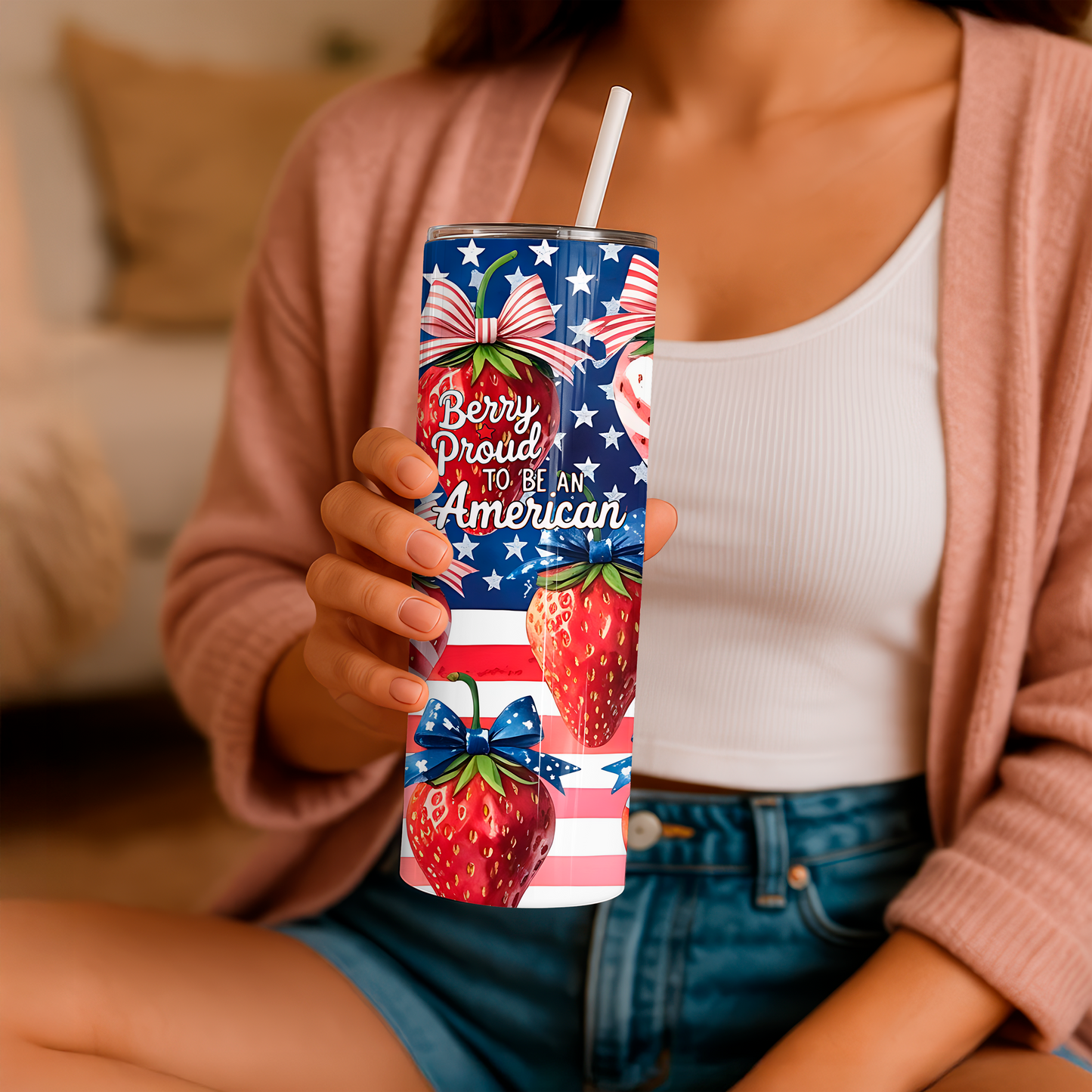 20oz tumbler with strawberry design and American flag print held by person wearing pink cardigan